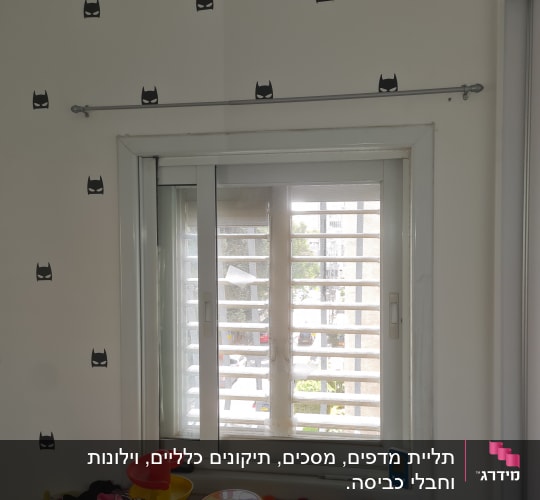 מוט תלוי מעל חלון עם מדבקות קיר